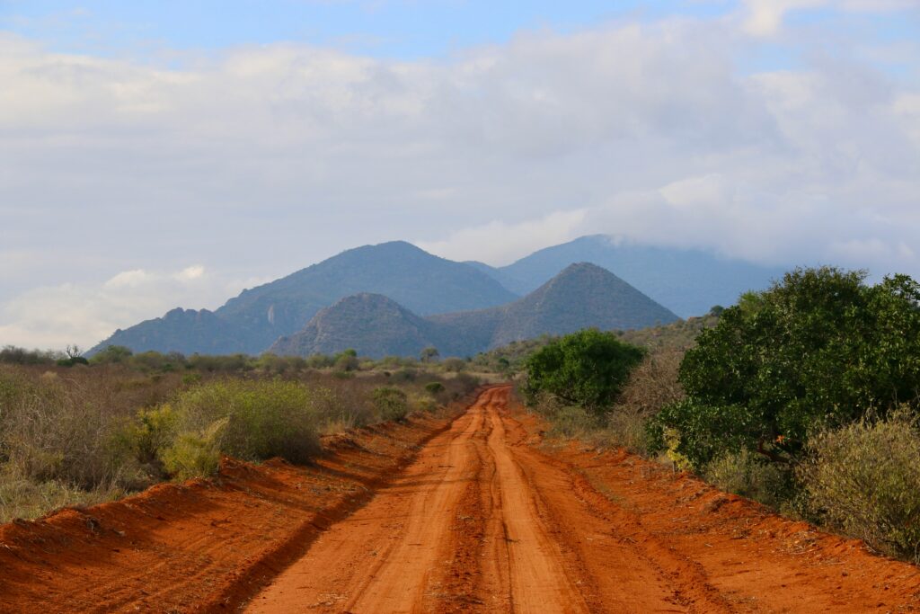Dirt road with trees and mountains in Kenya