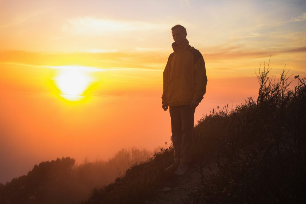 Traveler walking through a mountain landscape at sunrise