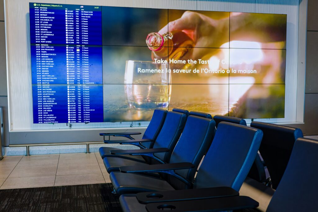 Airport waiting area with flight information display and seating.