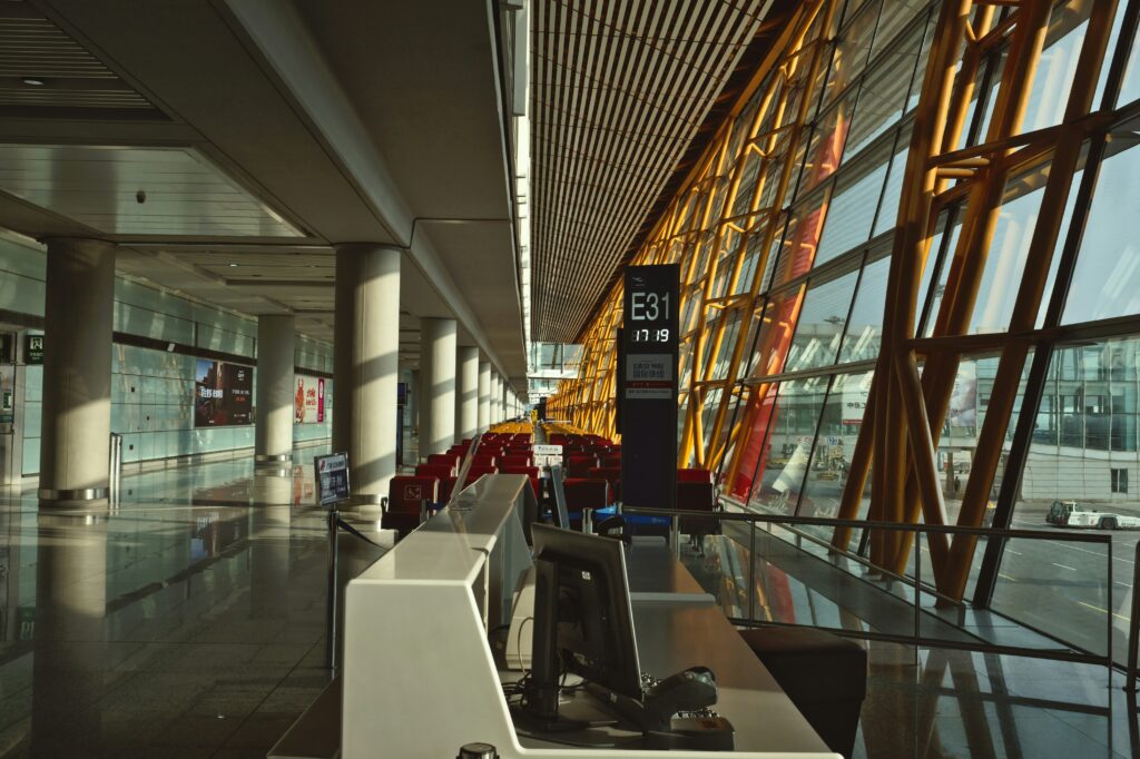 Bright airport terminal with travelers and natural light.