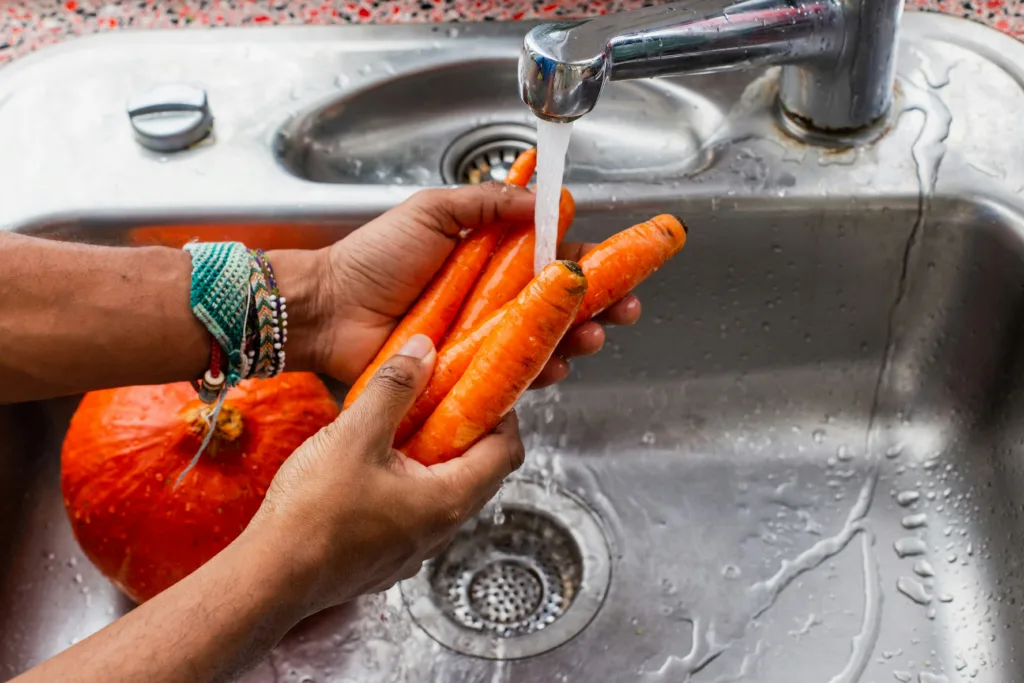 Traveler washing fresh produce before a trip — cyclospora outbreak travel prep